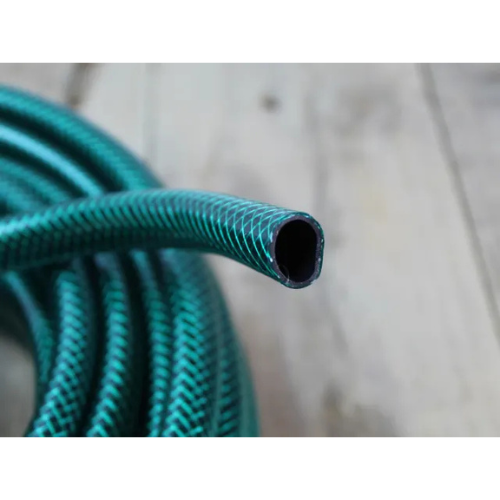 Close-up of a green garden hose on a wooden surface [ Davies DIY & Builders Merchants ]
